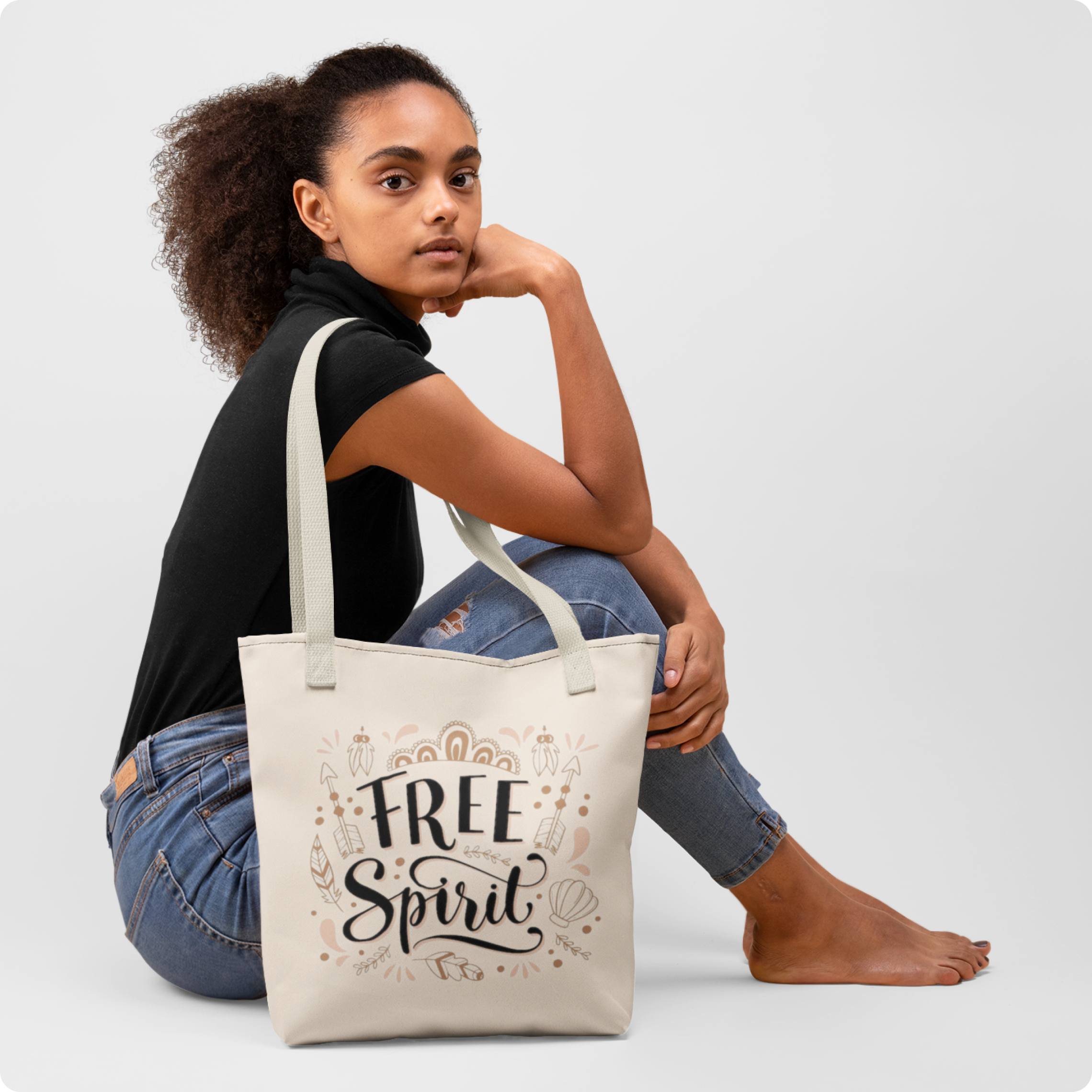 Woman sitting with a tote bag that has 'Free Spirit' text